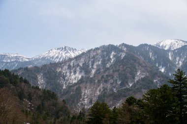 Kar Tozlu Dağlar ve Solgun Kış Gökyüzü Altındaki Evergreen Ormanları, Japon Alpleri. kamikochi nagano bölgesi