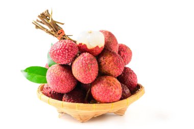 İkiye bölünmüş sulu Lychee ve beyaz arka planda izole edilmiş bambu sepetinin üzerinde yapraklar. Tayland meyvesi konsepti