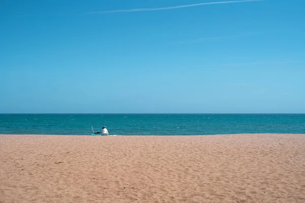 Una Donna Siede Sulla Sabbia Sulla Spiaggia Una Giornata Sole — Foto Stock