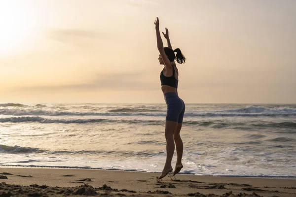 stock image beautiful young girl is engaged in fitness on the seashore at da