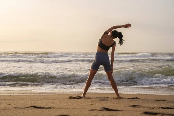 stock image beautiful young girl is engaged in fitness on the beach doing sl