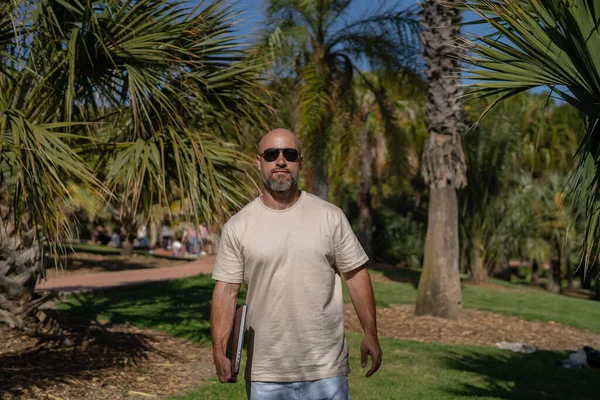 在公园里 留着胡子的男性自由职业者手里拿着笔记本电脑 — 图库照片
