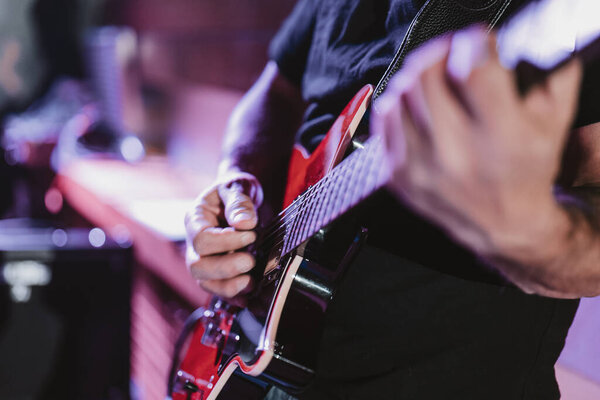 Man playing the guitar during a concert, no faces shown, Man playing the guitar during a concert, no faces shown, shallow depth of field