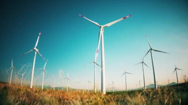 Gün batımında tarlada büyük yel değirmenleri. Rüzgâr türbinleri ve sahada bıçaklar. Alternatif enerji. 3d canlandırma