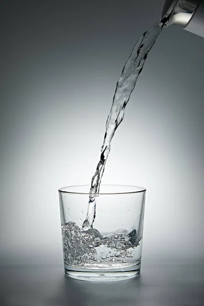 Verter Agua Una Tetera Vaso Sobre Fondo Gris Imagen De Stock
