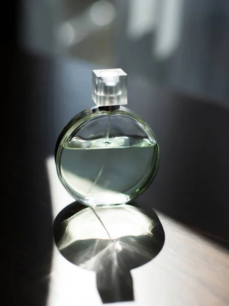 Parfümflasche Auf Holztisch Mit Schatten Auf Dem Boden lizenzfreie Stockfotos