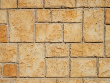 Orange decorative plaster imitating stone wall closeu