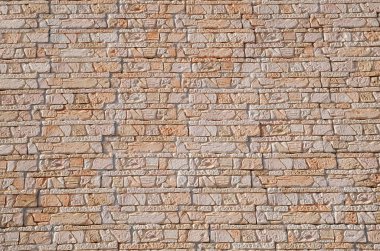 Orange cladding tiles imitating stone wall closeu