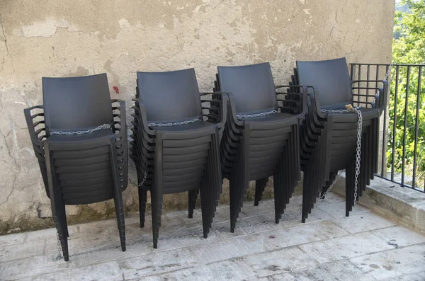 Stock image A bunch of stacked black chairs tied together with a chai