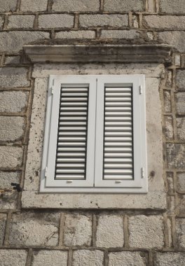 Geleneksel yeni beyaz pencere panjurları Europ 'taki eski taş evde panjur görevi görüyor