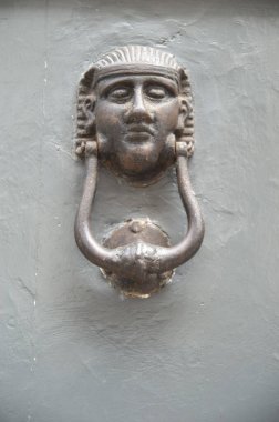 Tahta kapılar ardında Mısır şeklinde eski bir tokmak.