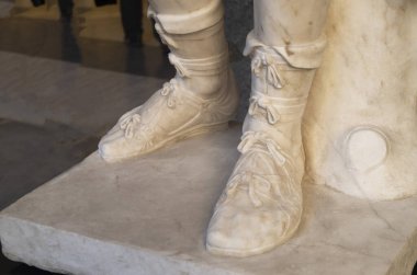 Ancient roman sandals on male legs of marble sculpture in Italy, Europ clipart