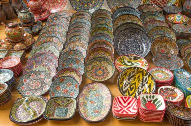 Özbekistan, Asi 'de pazarda renkli geleneksel Özbek tabakları ve bardakları boyadı