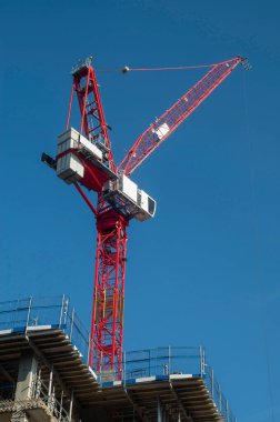 Büyük kırmızı vinç ve yeni yapılmış gökdelen mavi gökdelende