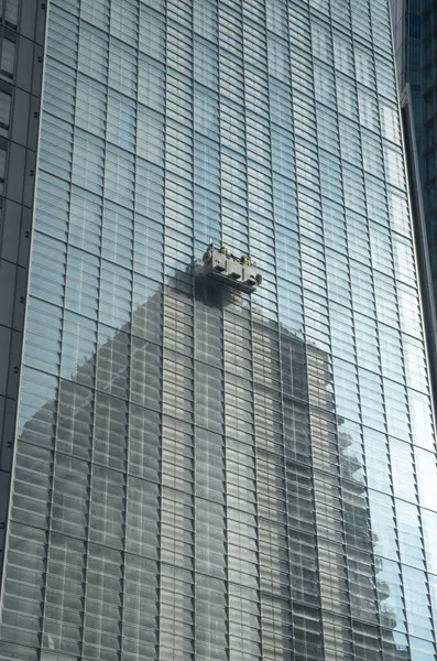 Bir gökdelenin pencerelerini bakım ünitesiyle temizlemek ve iki kişiyle beşik sallamak.