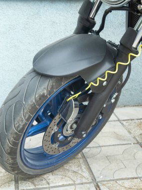 Motosiklet ön tekerleği disk kilidi alarm sistemiyle korunuyor.