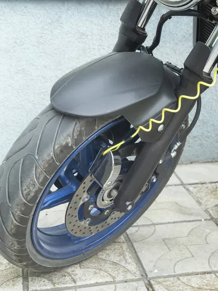 Motosiklet ön tekerleği disk kilidi alarm sistemiyle korunuyor.