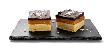 Millionaire's shortbread with chocolate and caramel isolated on white