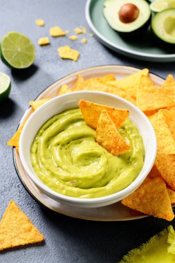 Avokado soslu guacamole ile tortilla mısır cipsi ve beyaz kase. .