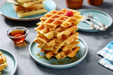 Taze ahududu ve akçaağaç şurubuyla taze pişmiş Belçika waffle 'ı. .
