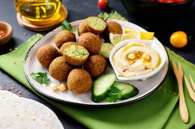 Bir tabak nohut köftesi, humus, sebze ve limon dilimleri..