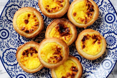 Pastel de nata veya Portekiz yumurtalı turtası. Çıtır börek hamurlu küçük tart ve kremalı krema, üst manzara.