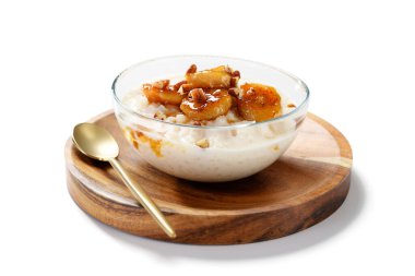 Karamelli muz, bal ve fındıklı taze pirinç pudingi. beyaz arkaplanda izole