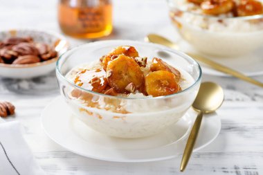 Karamelli muz, bal ve fındıklı taze pirinç pudingi. beyaz tahta arkaplan