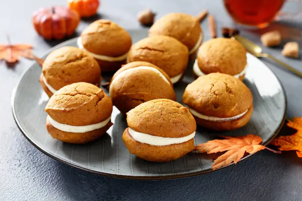 Pumpkin  sandwich cookies with cream cheese filling. gray background