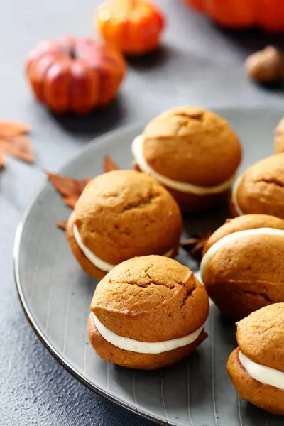 Pumpkin  sandwich cookies with cream cheese filling. gray background