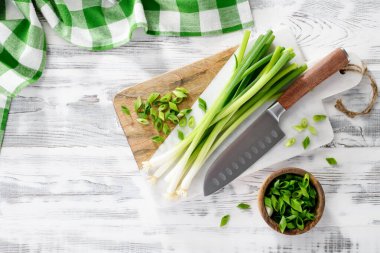 Tahta beyaz masada taze taze soğanlı mermer kesim tahtası, üst manzara.