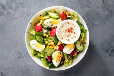 Marul, salatalık, turp, mısır ve haşlanmış yumurta ile taze yaz salatası. en üstteki görünüm