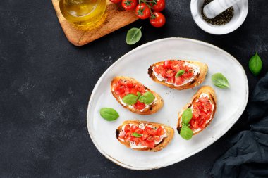 Taze fesleğen yapraklı vişneli domates ve krem peynirli bruschetalar. en üstteki görünüm