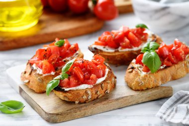 Taze fesleğen yapraklı vişneli domates ve krem peynirli bruschetalar..