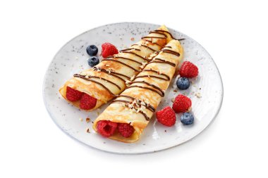 Krep ya da süzme peynirli ince krep, taze böğürtlen ve çikolata soslu fındık serpiştirilmiş. beyaz arkaplanda izole