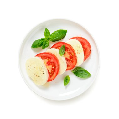 Taze domatesli Caprese salatası, mozzarella peyniri ve fesleğen. Beyaz arkaplanda izole edilmiş, üst görünüm