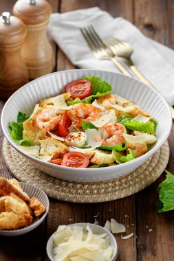 Klasik İtalyan Sezar Salatası. Ahşap arka planda karides var.