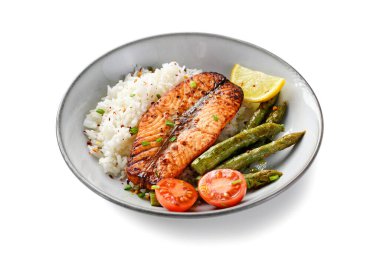 Pişmiş somon balığı bifteği, kuşkonmaz, kızarmış pirinç ve limon dilimi. Lezzetli öğle yemeği ya da her gün için akşam yemeği. Beyaz arkaplanda izole