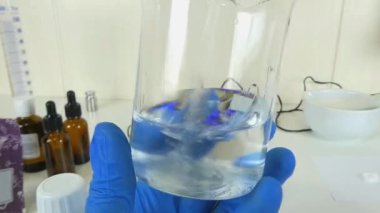 Profesyonel bir kozmetik laboratuvarında cam bir deney şişesinde şeffaf, şeffaf bir serumu sallama sürecini gösteren bir video. Klip, kozmetik formülasyonunda yer alan hassasiyet ve uzmanlığı ve cilt ürünleri oluşturulmasını vurguluyor. 