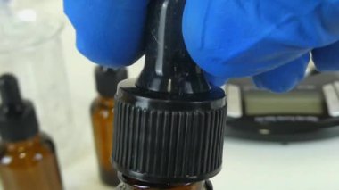 Profesyonel bir kozmetik laboratuvarında cam bir deney şişesinde şeffaf, şeffaf bir serumu sallama sürecini gösteren bir video. Klip, kozmetik formülasyonunda yer alan hassasiyet ve uzmanlığı ve cilt ürünleri oluşturulmasını vurguluyor. 