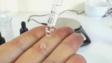 Profesyonel bir kozmetik laboratuvarında cam bir deney şişesinde şeffaf, şeffaf bir serumu sallama sürecini gösteren bir video. Klip, kozmetik formülasyonunda yer alan hassasiyet ve uzmanlığı ve cilt ürünleri oluşturulmasını vurguluyor. 