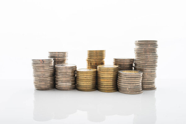Photo of Coins stacked on white backgroud with smooth reflection. Concept of home buget, saving money, wealth.