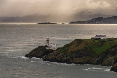 Fotoğraf: Howth Cliffs, Dublin, İrlanda. İrlanda kıyı şeridi, Howth Deniz feneri ve Kuzey Denizi ile bulutlu bir manzara. Uçurumların Yürüyüşü.