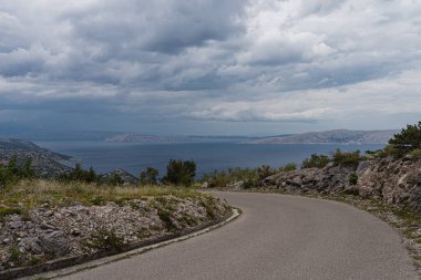 Hırvatistan 'ın küçük bir kasabası olan Sveti Juraj' ın Panoramik manzara fotoğrafı. Hava bulutlu. Krk Adası, Rab Adası ve ufukta Prvic Adası. Dağ yolu