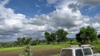 Gökyüzü manzarası ağaçlarla ve bulutlarla dolu.