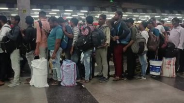 Yolcular bir metro treni bekliyor.