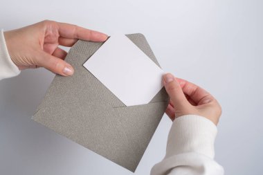 Kadın el kâğıdı zarf ve kutu tutuyor. Yeni posta, mesaj. Posta servisi. Genç kız mektup ya da paket istiyor. Boş zarf, boş alan. İnsanlarla iletişim. Zarf kapatma