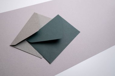 Hafif arka planda kağıt zarflar. Yeni posta, bir mesaj yaz. Gönder ve al. Posta servisi. Boş zarf, boş alan. İnsanlarla iletişim, evrak işleri. Zarfı kapat.