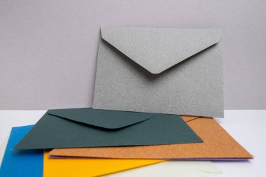Hafif arka planda kağıt zarflar. Yeni posta, bir mesaj yaz. Gönder ve al. Posta servisi. Boş zarf, boş alan. İnsanlarla iletişim, evrak işleri. Zarfı kapat.