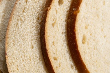 Tahtada taze kesilmiş beyaz ekşi ekmek. Kahvaltı için lezzetli hamur işleri.